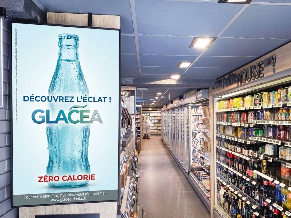 Un écran publicitaire à l'entrée du rayon boissons d'une supérette